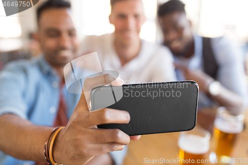 Image of friends taking selfie and drinking beer at bar