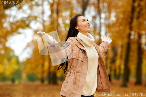 Image of beautiful happy young woman in autumn park