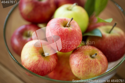 Image of ripe apples in glass bowl on wooden table