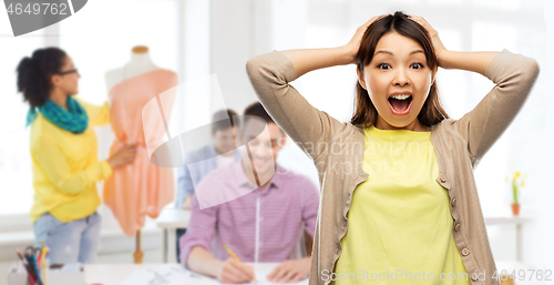 Image of happy asian woman holding to her head