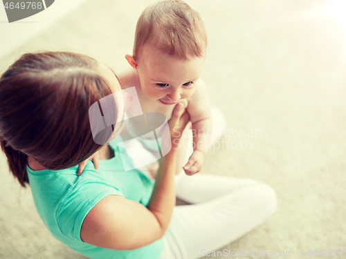 Image of happy young mother with little baby at home