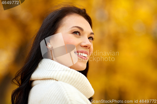 Image of portrait of happy young woman in autumn park