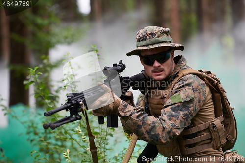 Image of soldier in action aiming  on weapon  laser sight optics