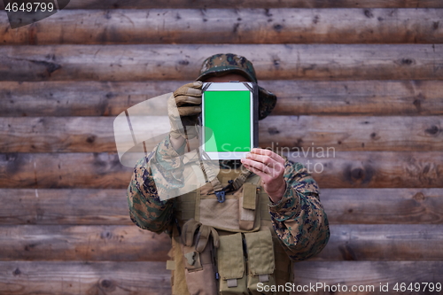 Image of soldier using tablet computer in military camp