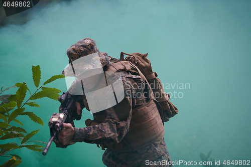 Image of soldier in action aiming  on weapon  laser sight optics