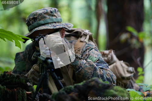 Image of soldier in action aiming  on weapon  laser sight optics