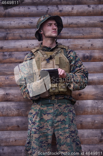 Image of soldier using tablet computer in military camp