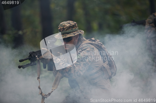 Image of soldier in action aiming  on weapon  laser sight optics