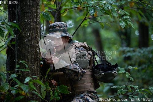 Image of soldier in action aiming  on weapon  laser sight optics