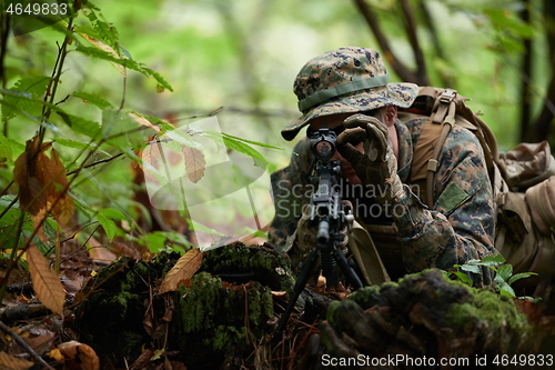 Image of soldier in action aiming  on weapon  laser sight optics