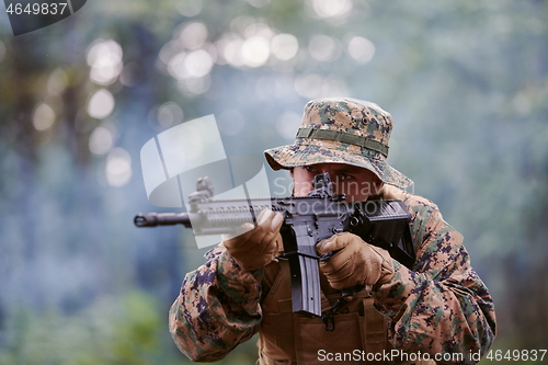 Image of soldier in action aiming  on weapon  laser sight optics