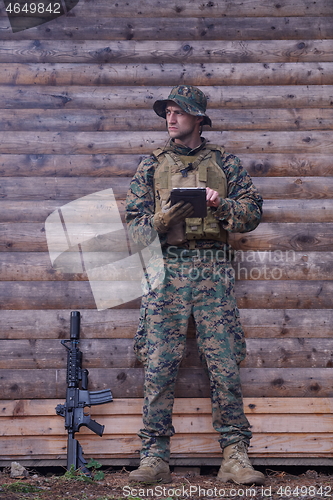 Image of soldier using tablet computer in military camp