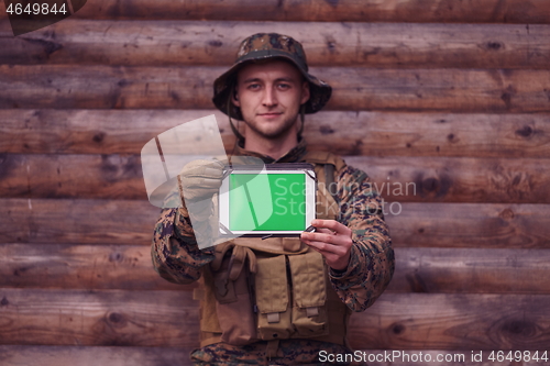 Image of soldier using tablet computer in military camp