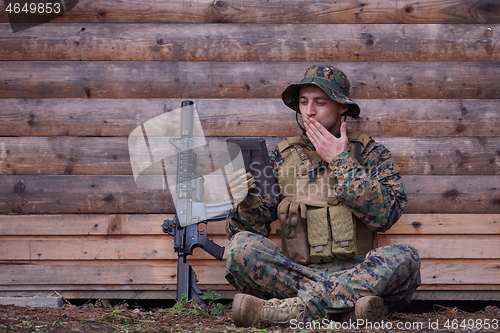 Image of soldier using tablet computer in military camp