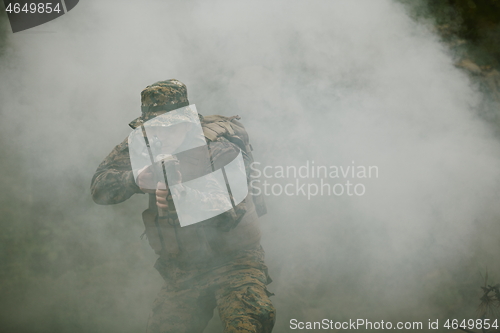 Image of soldier in action aiming  on weapon  laser sight optics