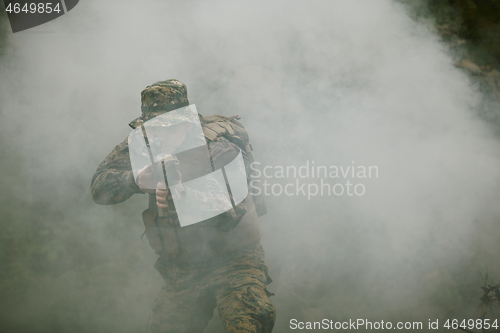 Image of soldier in action aiming  on weapon  laser sight optics