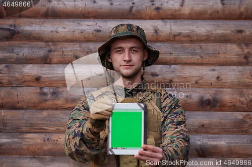 Image of soldier using tablet computer in military camp