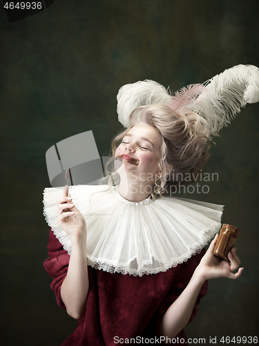 Image of Young woman as Marie Antoinette on dark background. Retro style, comparison of eras concept.