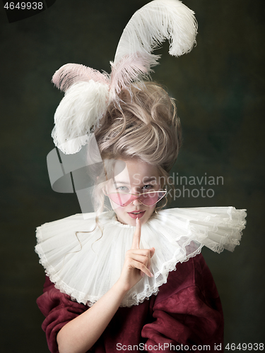 Image of Young woman as Marie Antoinette on dark background. Retro style, comparison of eras concept.