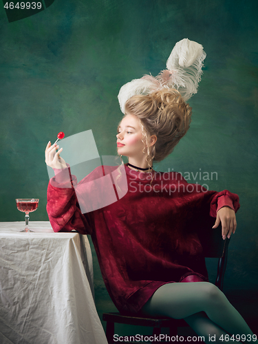 Image of Young woman as Marie Antoinette on dark background. Retro style, comparison of eras concept.