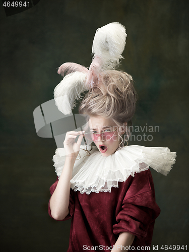 Image of Young woman as Marie Antoinette on dark background. Retro style, comparison of eras concept.