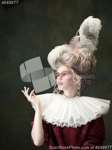 Image of Young woman as Marie Antoinette on dark background. Retro style, comparison of eras concept.