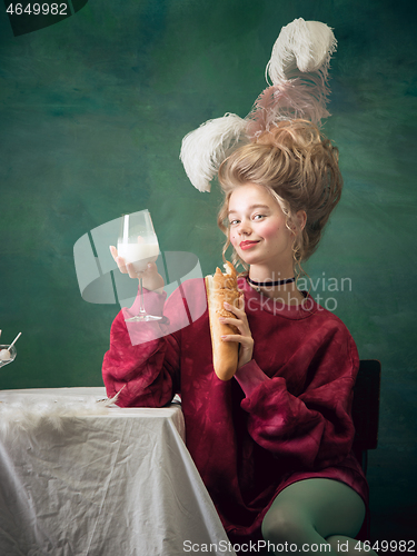 Image of Young woman as Marie Antoinette on dark background. Retro style, comparison of eras concept.