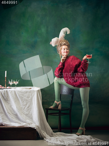 Image of Young woman as Marie Antoinette on dark background. Retro style, comparison of eras concept.