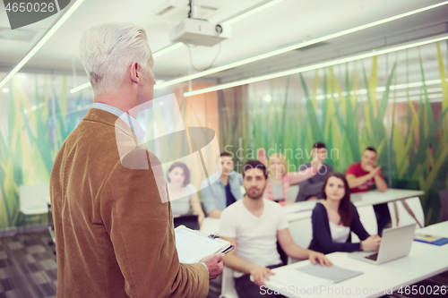 Image of teacher with a group of students in classroom