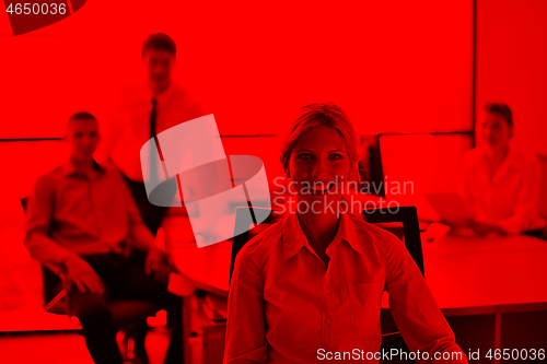 Image of business woman with her staff in background at office