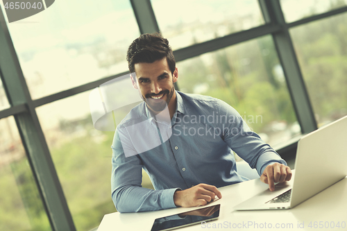Image of happy young business man at office
