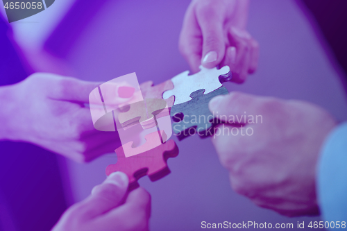 Image of Group of business people assembling jigsaw puzzle