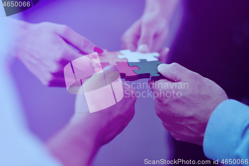 Image of Group of business people assembling jigsaw puzzle