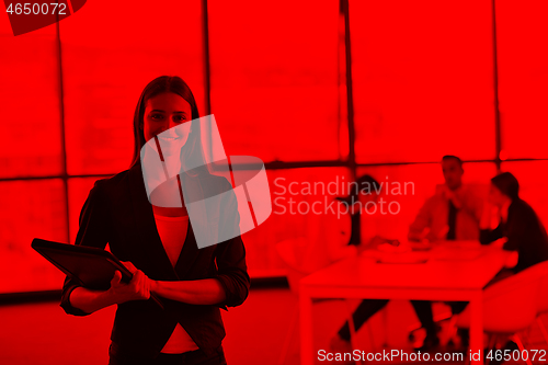 Image of business woman with her staff in background at office