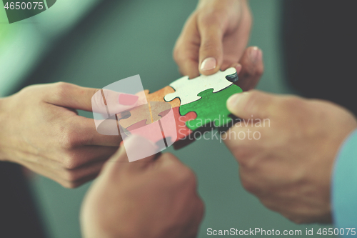 Image of Group of business people assembling jigsaw puzzle