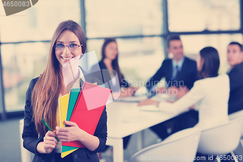 Image of business woman with her staff in background at office