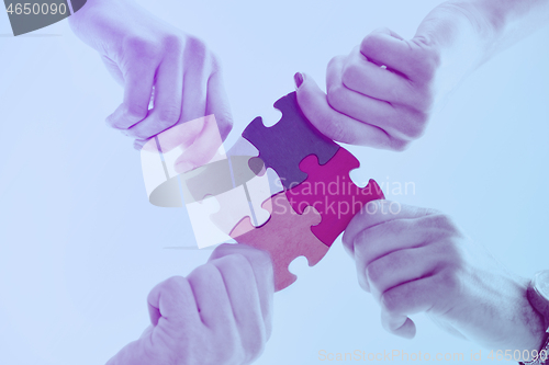 Image of Group of business people assembling jigsaw puzzle