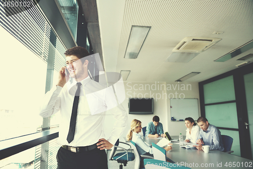 Image of business man  on a meeting in offce with colleagues in backgroun