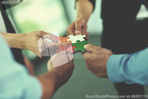 Image of Group of business people assembling jigsaw puzzle