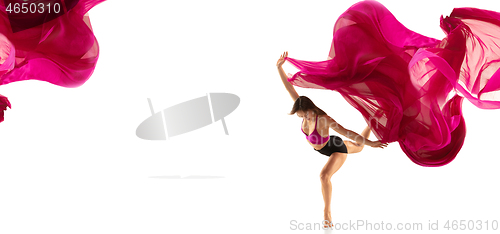 Image of Ballerina. Young graceful female ballet dancer dancing over white studio. Beauty of classic ballet.