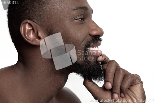 Image of Close up portrait of a young naked african man indoors