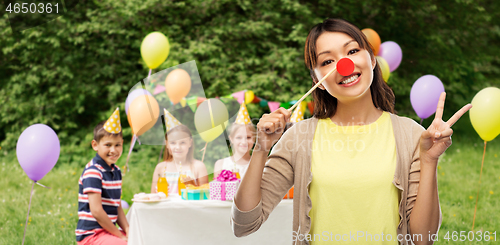 Image of woman with clown nose at children\'s birthday party