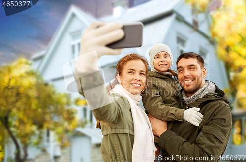 Image of family taking selfie over house in autumn