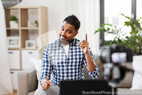 Image of male blogger with camera videoblogging at home