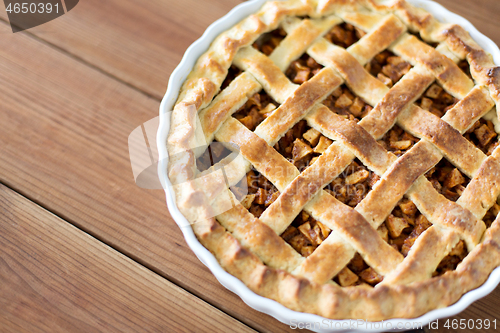 Image of close up of apple pie in mold on wooden table