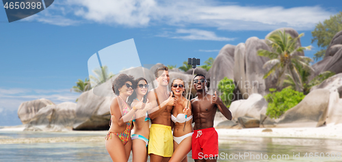 Image of friends taking selfie on beach and show thumbs up