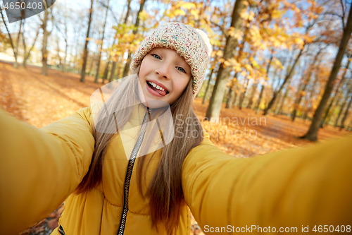 Image of happy girl taking selfie at autumn park