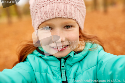 Image of happy girl taking selfie at autumn park