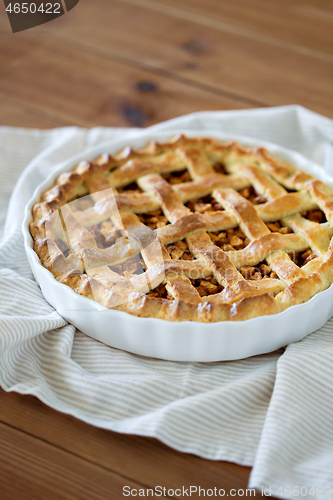 Image of close up of apple pie in mold on wooden table