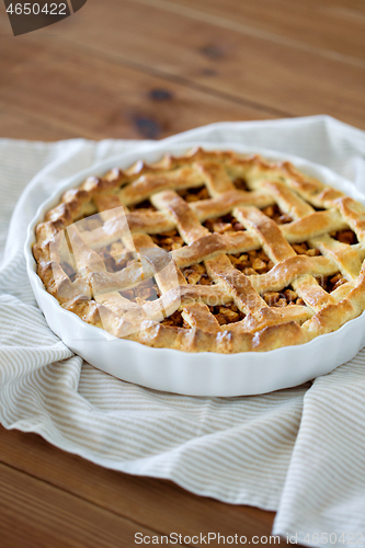 Image of close up of apple pie in mold on wooden table
